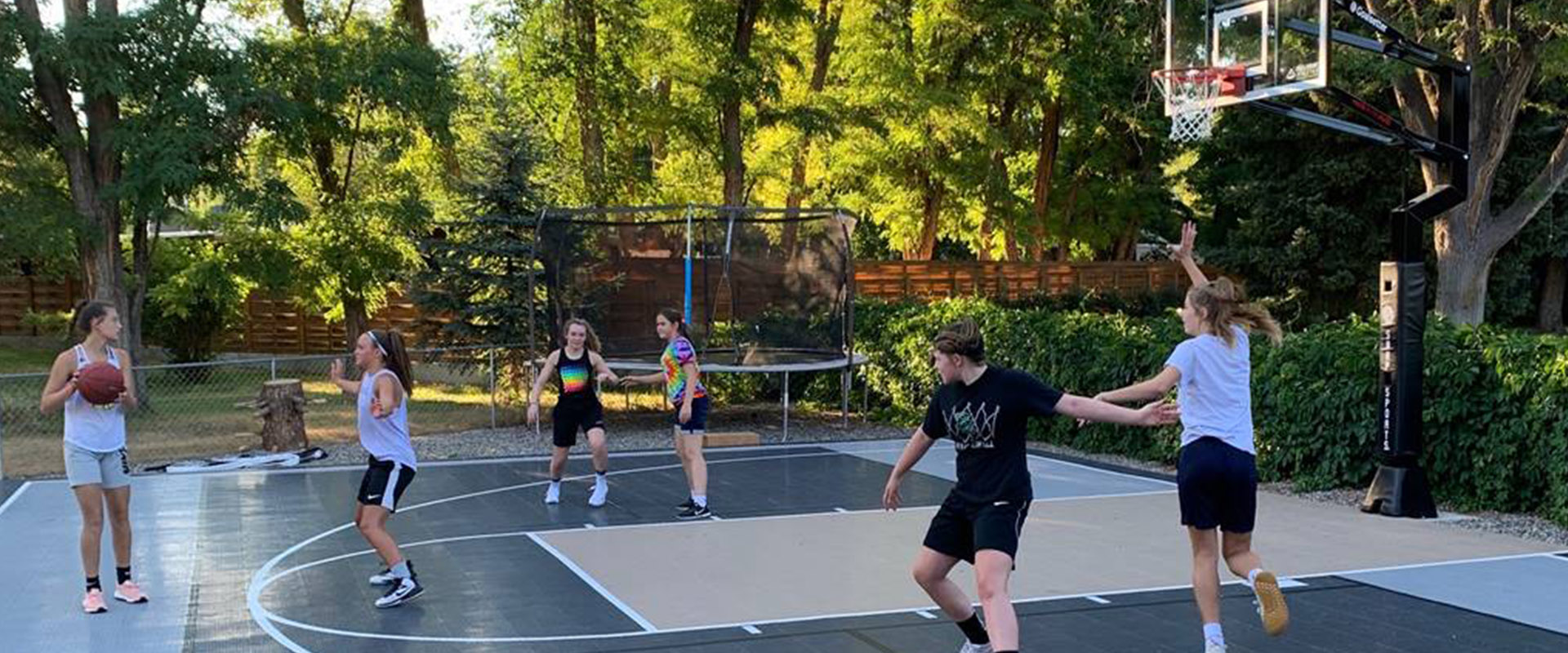 Friends playing a game on their backyard half court