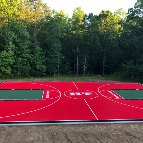 Outdoor full basketball court in red with green and black accents