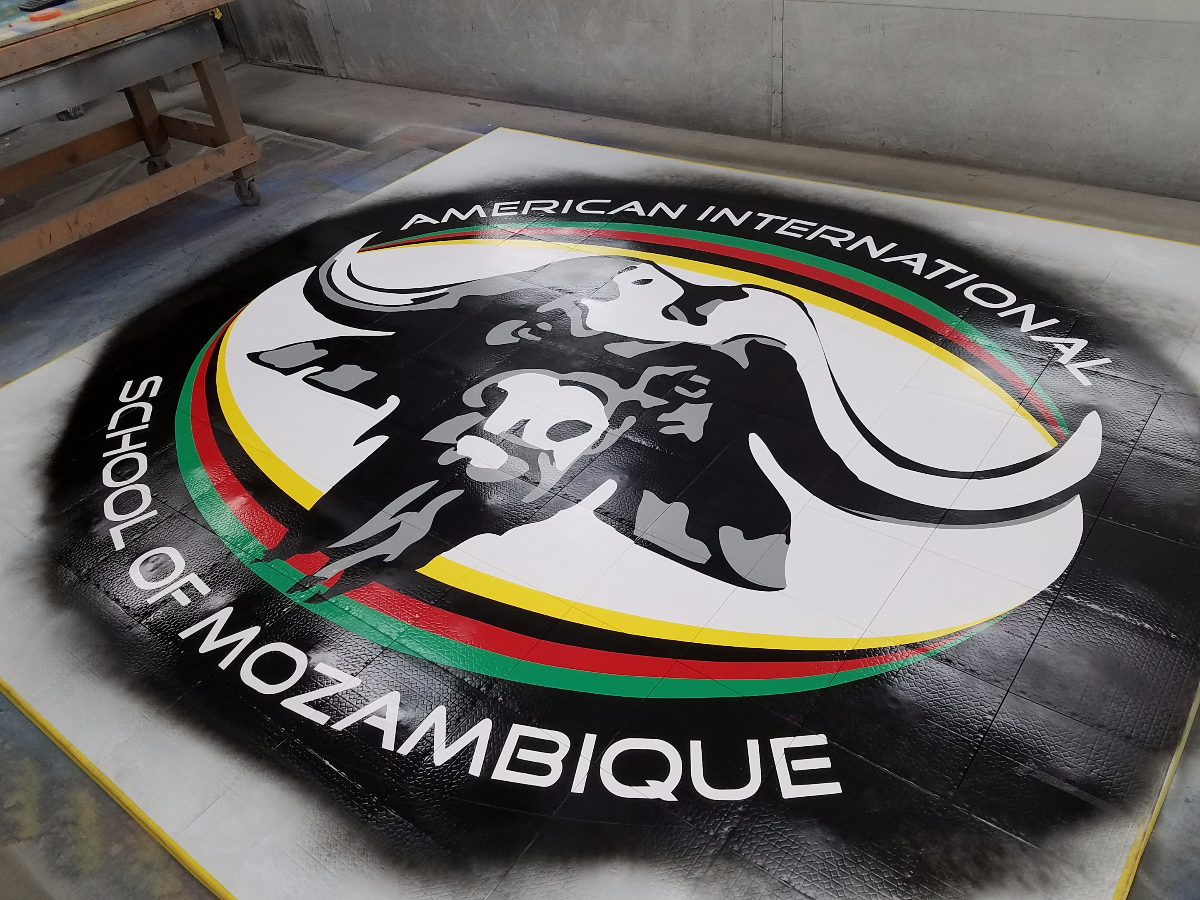 The American International School of Mozambique logo painting in progress