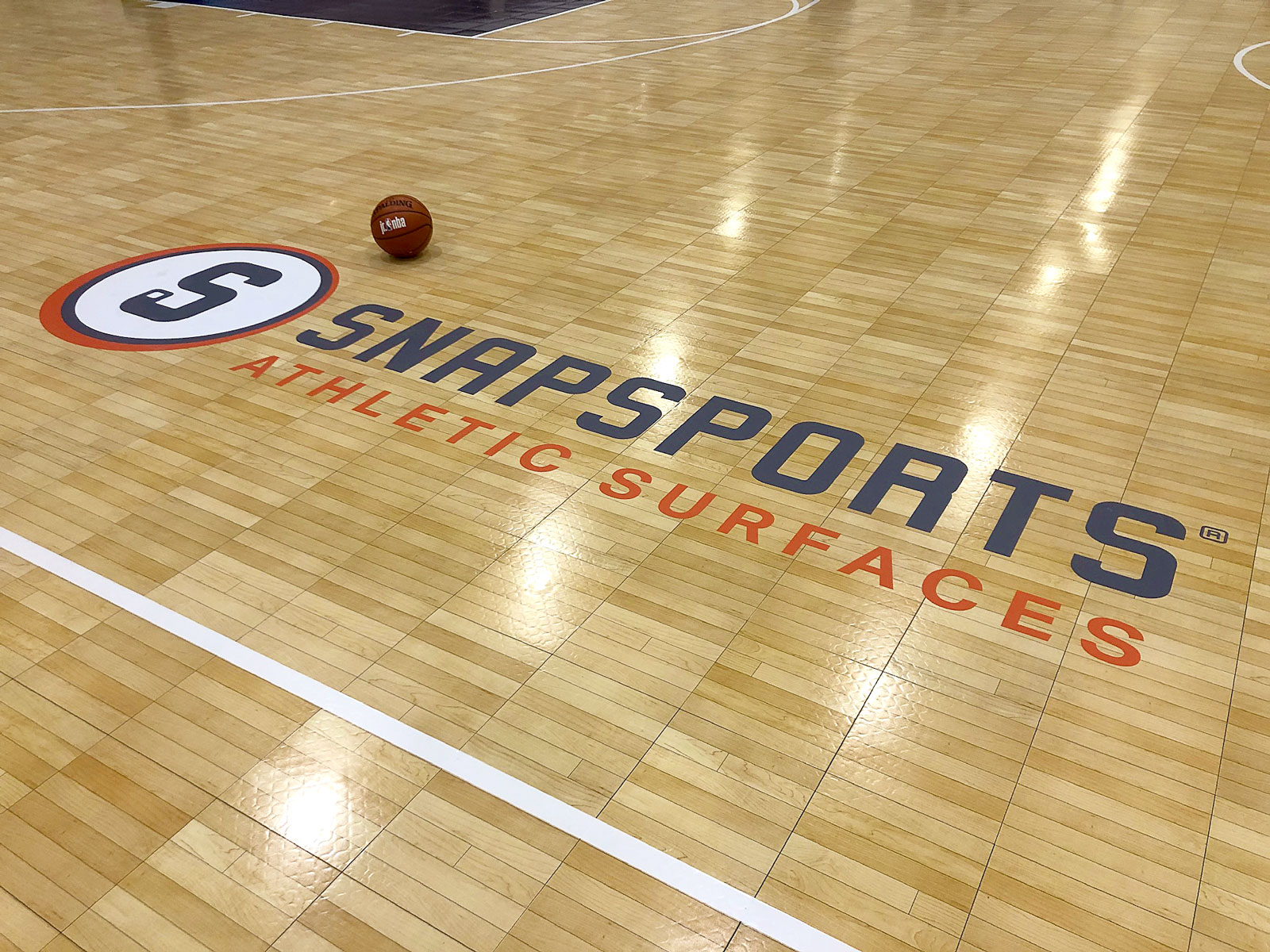 SnapSports Athletic Surfaces logo on the Maple TuffShield flooring