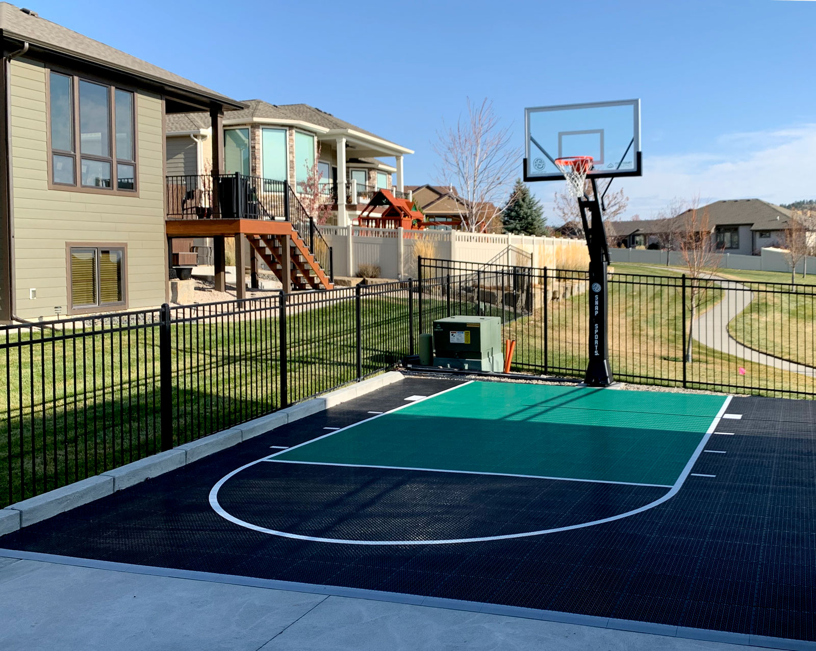 Small basketball half court with black and shamrock colors