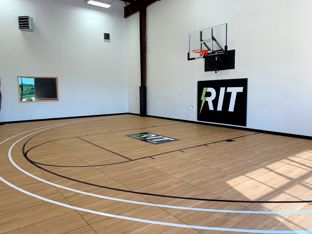Indoor basketball half-court with Pro36 maple style flooring and custom floor logo