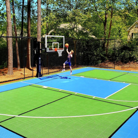 Kid making the shot on blue and green backyard multi-court