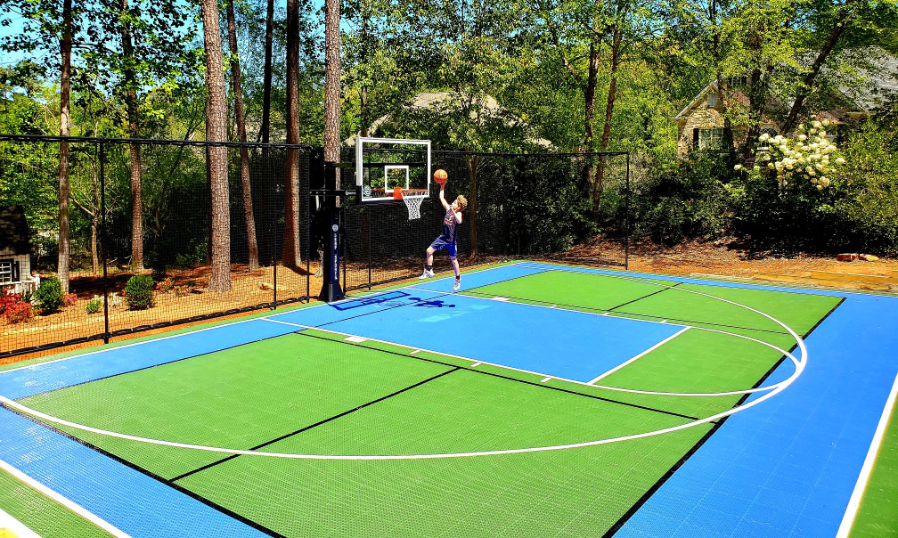 Kid making the shot on blue and green backyard multi-court