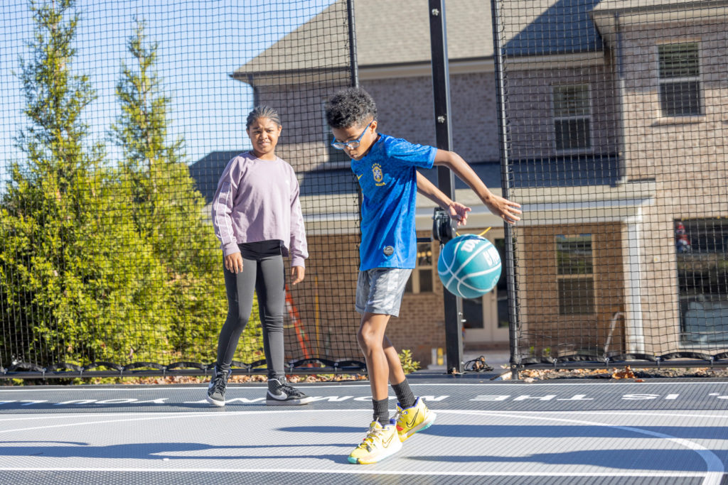 Kids playing basketball in their backyard court