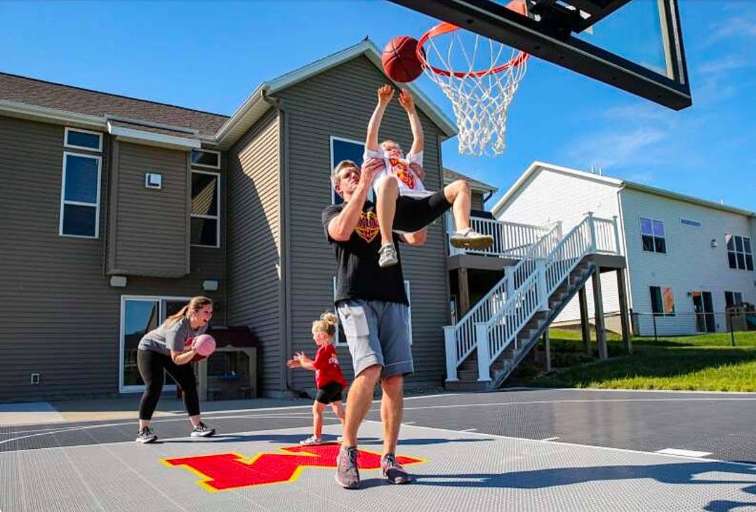 Family with kids playing basketball in the backyard