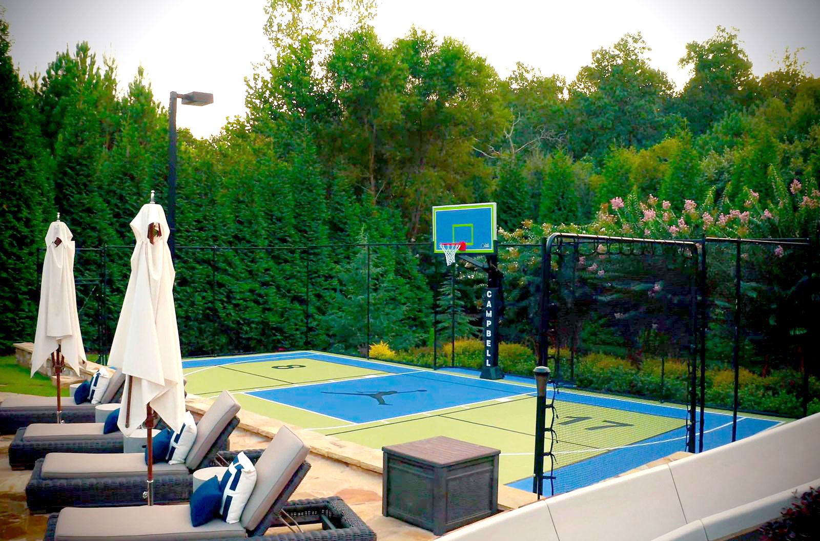 Alternate view of backyard multi-court with fencing, SnapBack, basketball hoop and lighting