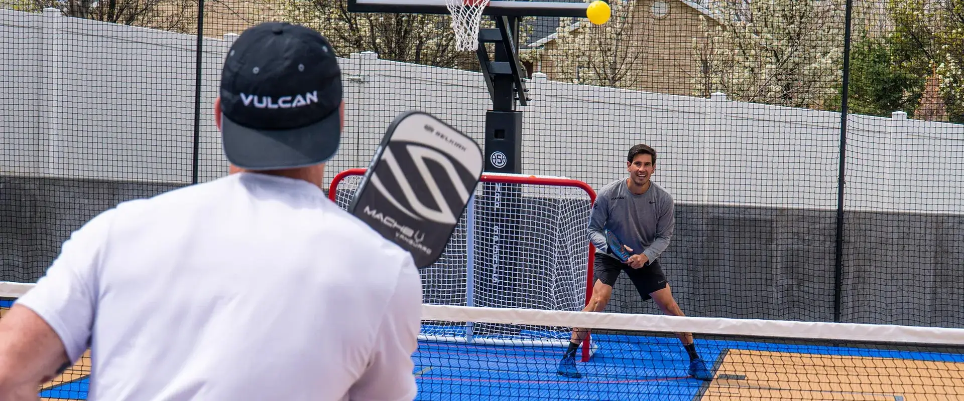 Tyler Loong and friend play pickleball on a backyard multi-court