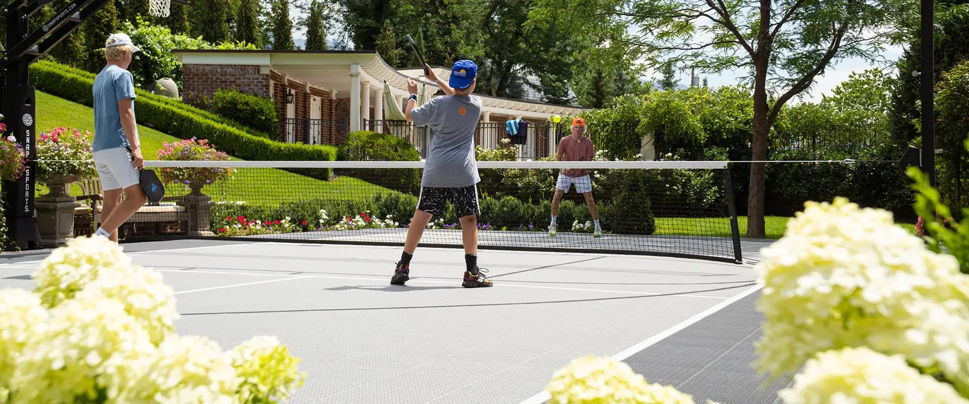 Brothers playing a game of pickleball cutthroat on their home court
