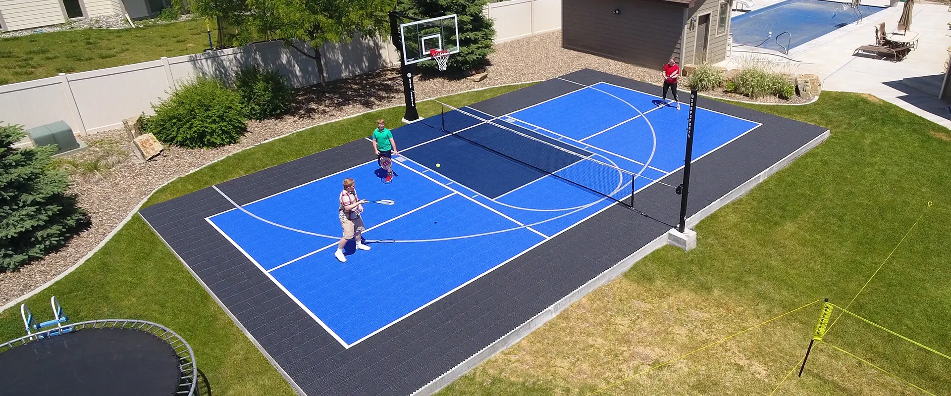 Family plays tennis on their home multi-court