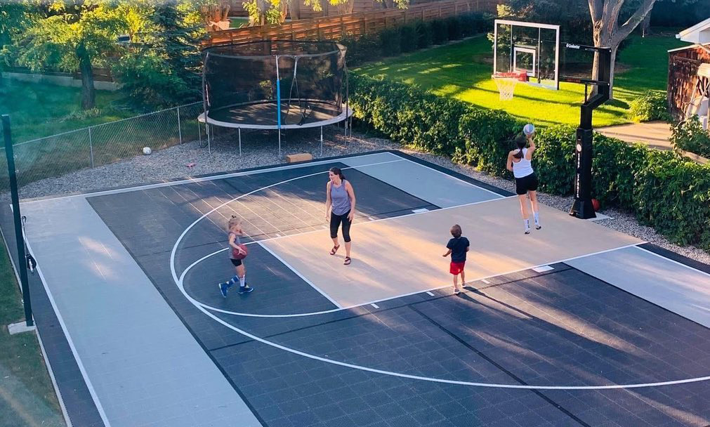 Family playing basketball on a backyard multi-court