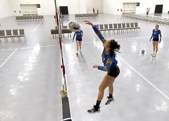 volleyball courts spike Women practice volleyball in a training facility with 50-50