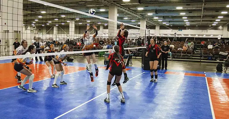 commercial volleyball courts Young women play a championship match on a SnapSports 50-50 volleyball court.