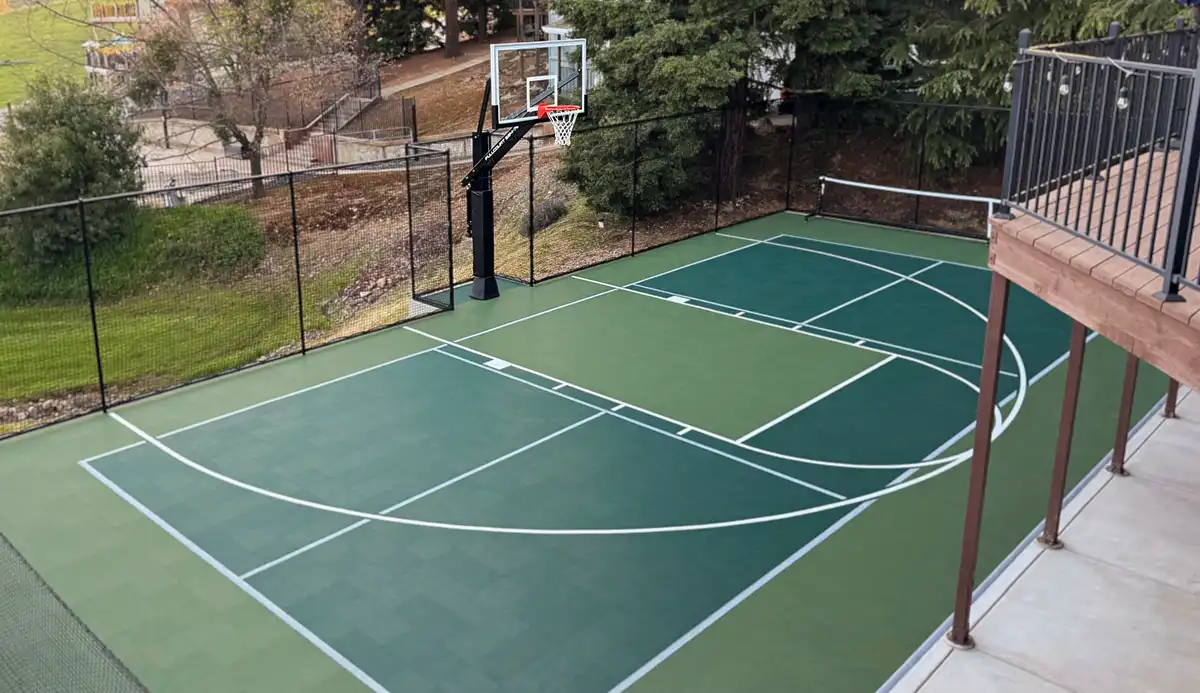 hooper family multi court Angled view of the Hooper family Multi court.The court is green with a shamrock accent for the pickleball area. The family's deck overlooks the court.