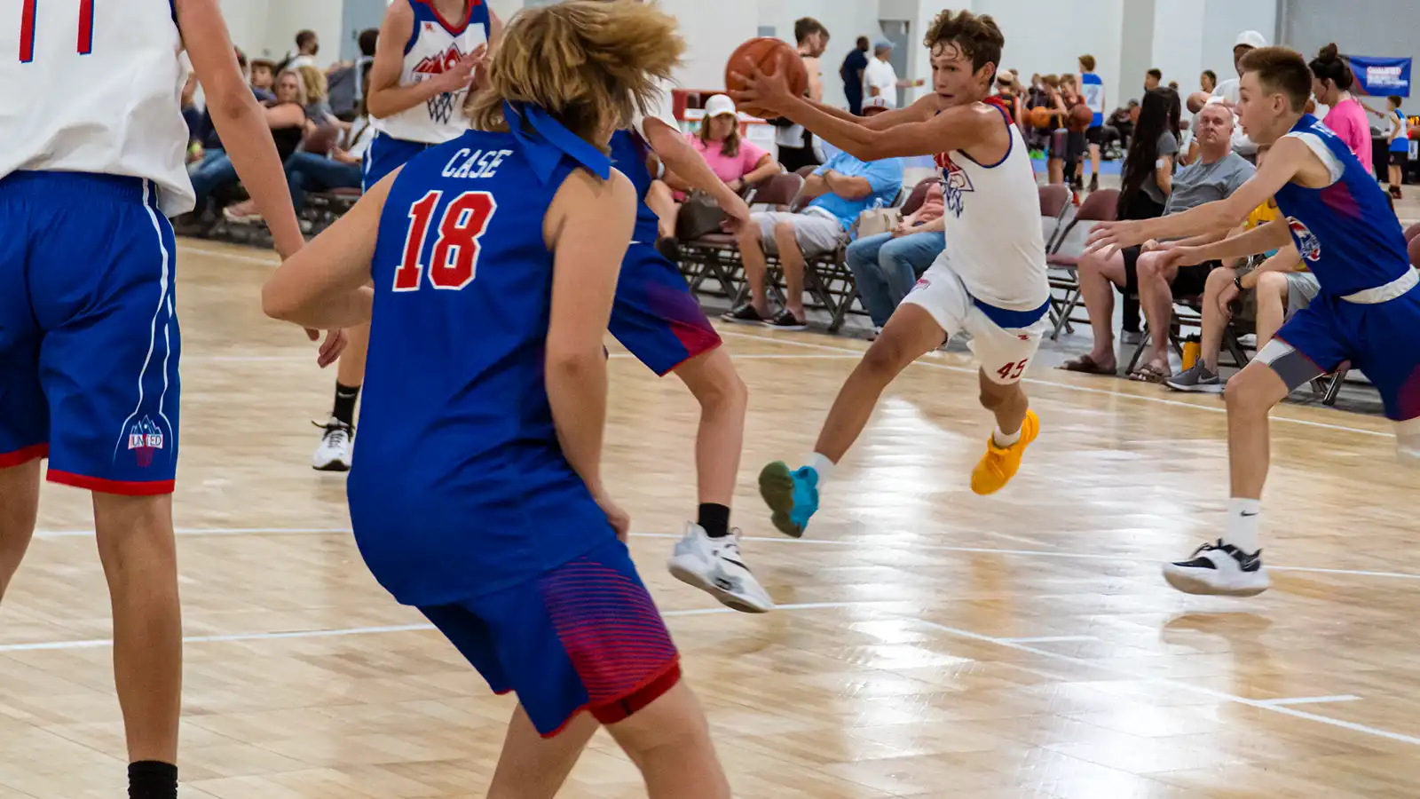 trusted by the best in the industry two teams play basketball on a SnapSports Gymnasium floor during a AAU basketball tournament .